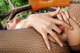 A woman in fishnet stockings is laying on a wooden bench.