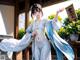 A woman in a white and blue kimono holding a sign.