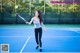 A woman holding a tennis racquet on a tennis court.