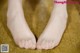 A pair of bare feet on a carpeted floor.