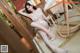 A woman in a white lingerie sitting on a chair.
