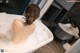 A woman sitting in a bathtub with foam on her back.