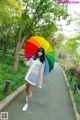 A woman walking down a path holding an umbrella.